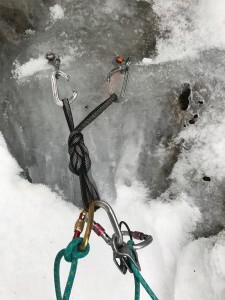 Placing ice screws in a misty No.2 Gully, Ben Nevis.